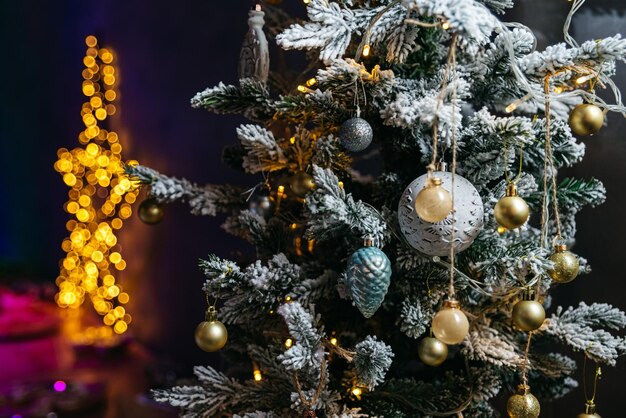 Árbol de Navidad decorado con juguetes y guirnaldas sobre fondo oscuro Luces borrosas en forma de estrella