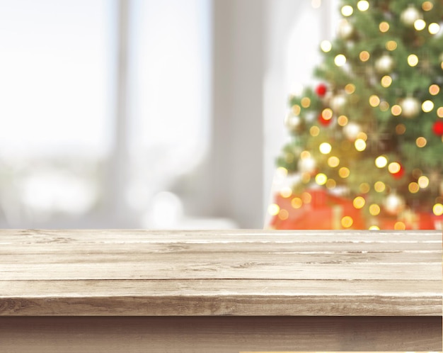 Árbol de navidad defocused bokeh de fondo con mesa de madera