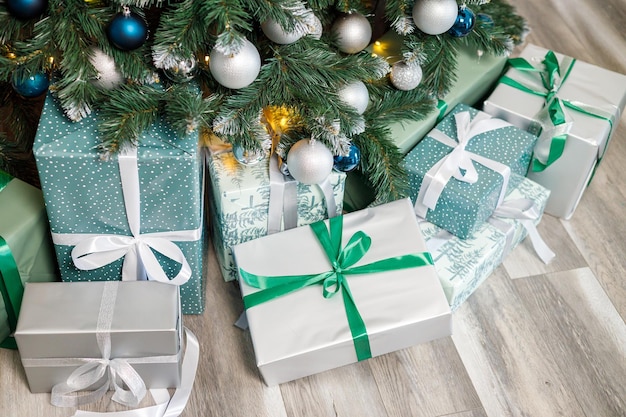 El árbol de Navidad está decorado con juguetes y guirnaldas con regalos debajo. Regalos de Navidad debajo del árbol.