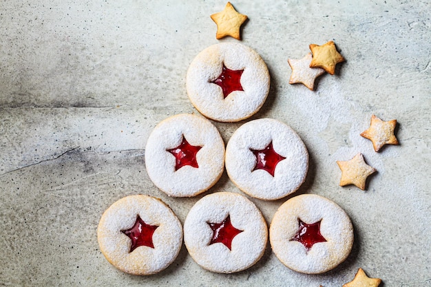 Árbol de navidad de galletas linzer de fresa sobre fondo gris Postre festivo regalo de invierno