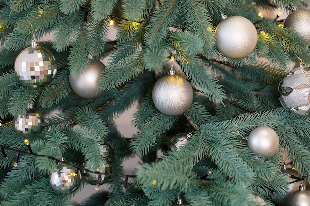 Árbol de Navidad con juguetes de adornos de plata. El año nuevo es pronto