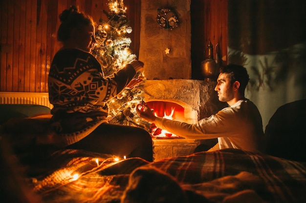 Foto Árbol de navidad junto a la chimenea. concepto de decoraciones navideñas.