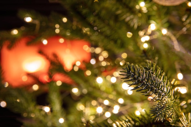 El árbol de navidad y las luces cierran el fondo de la chimenea ardiente