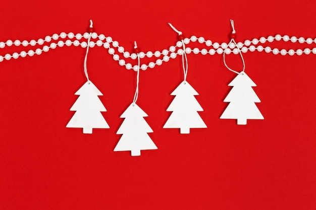 Árbol de Navidad de madera blanca colgando de perlas de decoración.