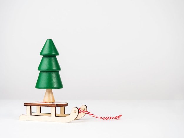 Foto un árbol de navidad de madera en un trineo el concepto de navidad y año nuevo