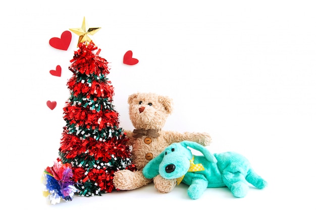 El árbol de Navidad con un osito de peluche y un lindo cachorro son sensaciones felices en año nuevo.