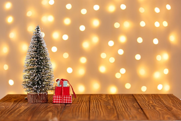 Foto Árbol de navidad reloj trineo muñeco de nieve velas regalos sobre un fondo de madera y luces de fondo