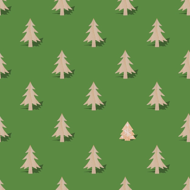 Árboles de Navidad de madera con sombra sobre fondo verde de patrones sin fisuras