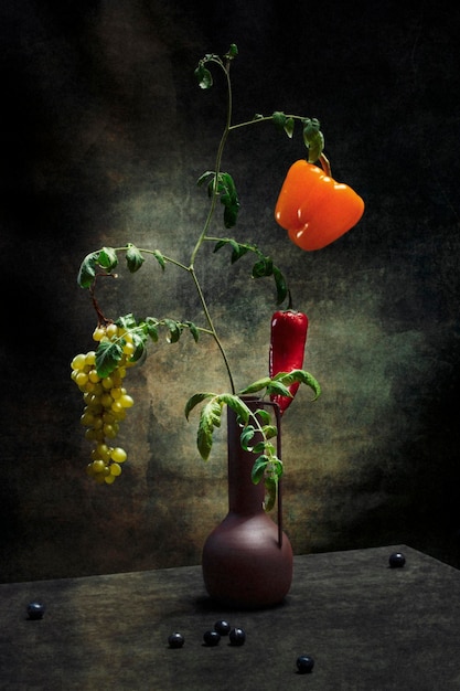 Arbusto de tomate com frutas de pimenta e um cacho de uvas nos galhos