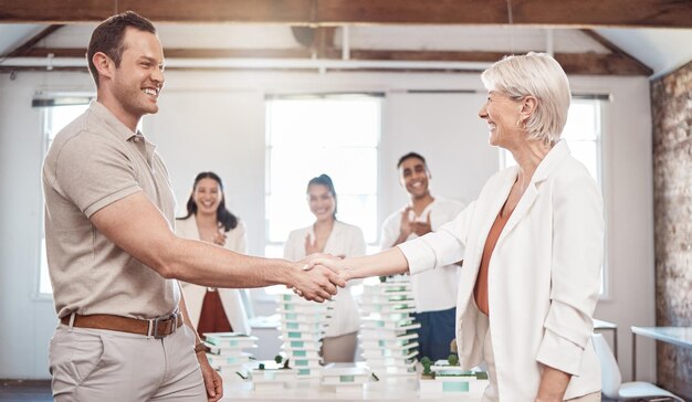 Architekt Business Handshake und Partnerschaftstreffen von Menschen, die sich auf den Architekturplan im Büro einigen Fröhliche Seniorin und junger Mann schütteln sich bei der Arbeit für Teamarbeit die Hände