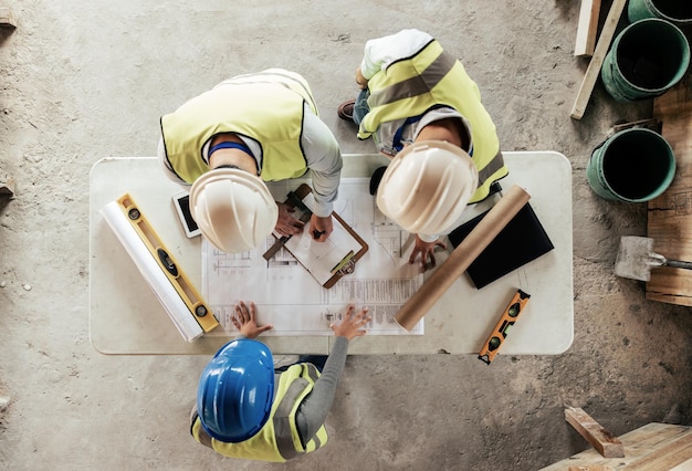 Foto architekt ingenieur und teamarbeit mit blaupause von oben an einem bau- oder auftragnehmerprojekt gebäudekonstruktionsteam und architekturentwurfsskizze mit personen, die ein renovierungsprojekt planen