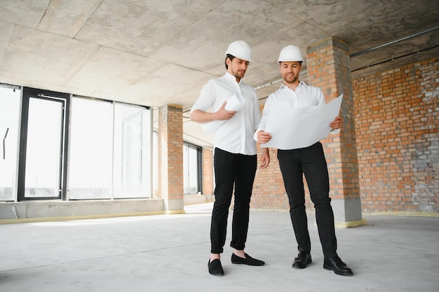 Architekt mit zwei jungen Männern auf einer Hochbausite