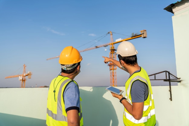 Architekt und Ingenieur zur Inspektion und Überwachung der Position des Baukrans auf der Baustelle