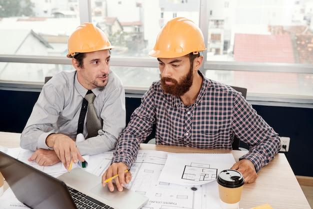 Architekten arbeiten mit Laptop und Blaupause