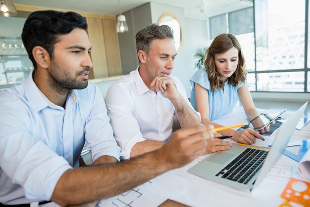 Architekten diskutieren über Laptop im Konferenzraum