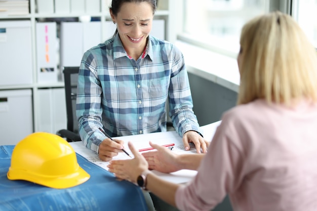 Architektin kommuniziert mit dem Kunden im Büro. Hausdesignkonzept