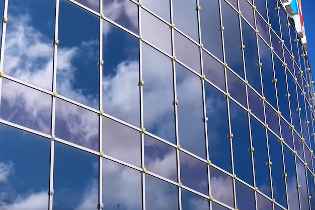 Architektonisches Detail der Fassade mit Mehrfachreflexionen anderer Gebäude und der Sonne. Äußeres des modernen Gebäudes. Architektur abstrakter Hintergrund