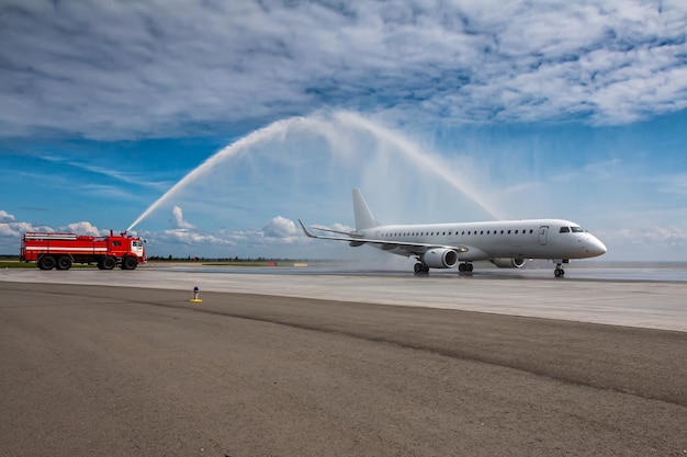 Arco de agua para el avión de pasajeros blanco de primera visita en el aeropuerto