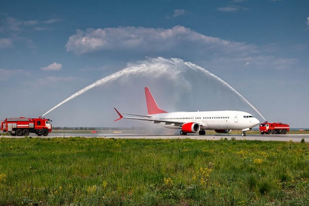 Arco de agua para la primera visita del avión de pasajeros blanco en el aeropuerto