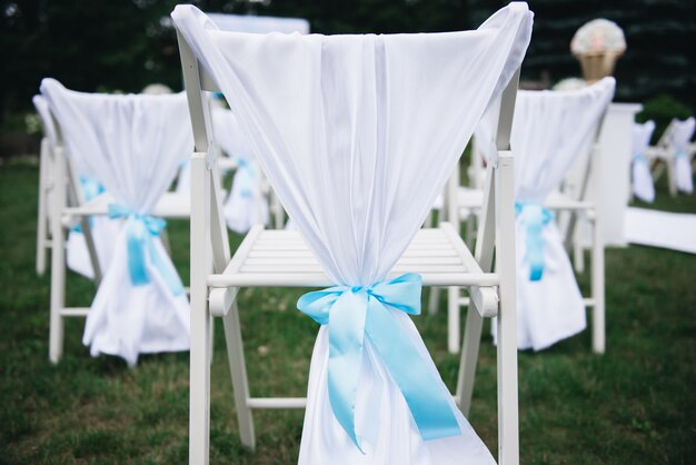 Arco de boda decorado con tela y flores al aire libre. Hermosa boda organizada. Ceremonia de boda en césped verde en el jardín.