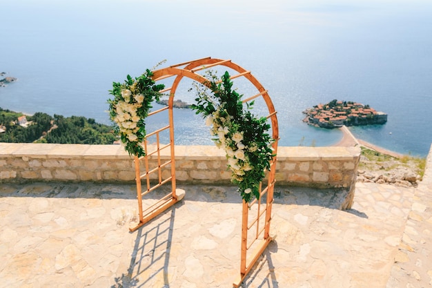 El arco de la boda se encuentra en la plataforma de observación con vistas a la isla de sveti stefan