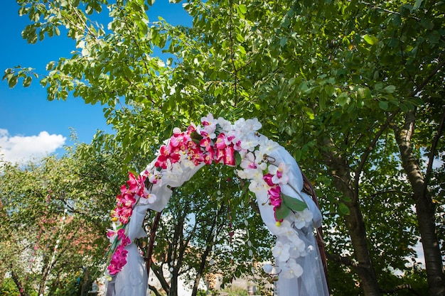 Arco de boda con flores blancas y rosas.