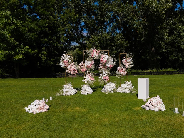 arco de boda de follaje y flores blancas y rosas