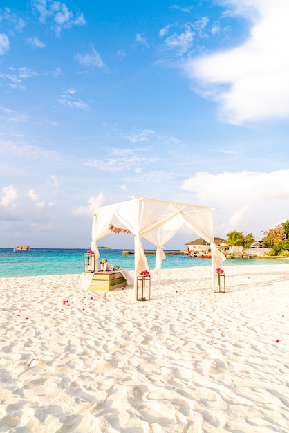 Arco de boda en la playa con el mar y resort tropical de Maldivas