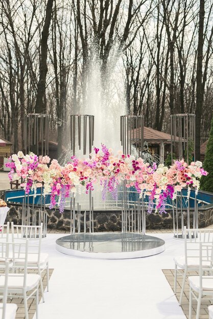 Arco de bodas decorado con flores rosas y blancas en la zona de lujo de la boda