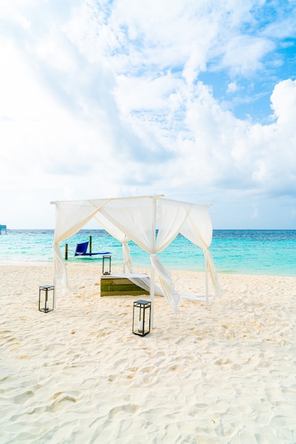 Arco de bodas en la playa con el complejo tropical de Maldivas y el mar