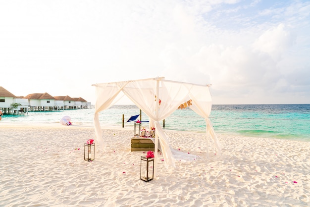 Arco de bodas en la playa con el complejo tropical de Maldivas y el mar