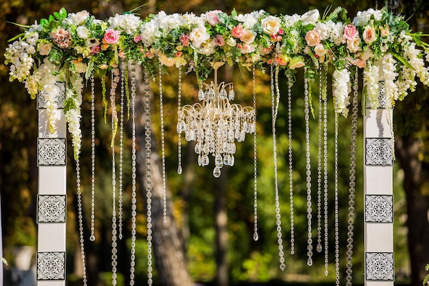 Arco para la ceremonia de la boda Decorado con candelabro de cristal y flores frescas Decoraciones de boda Los recién casados