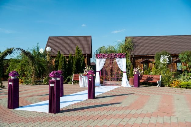 Arco para la ceremonia de boda, decorado con tela y flores.