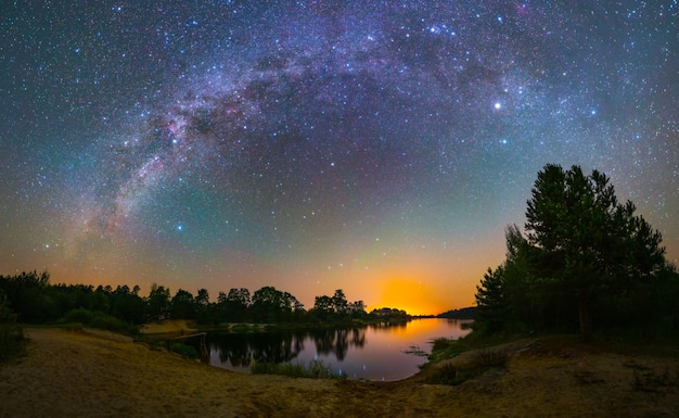 Arco da Via Láctea sobre um lago, foto noturna