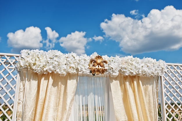 Foto arco de casamento com flores brancas e ornamentos de ouro