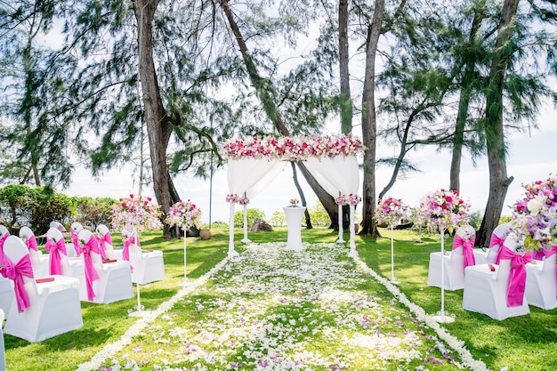 Arco de casamento de praia, altar decorado com rosas, rosas vermelhas, brancas e flores