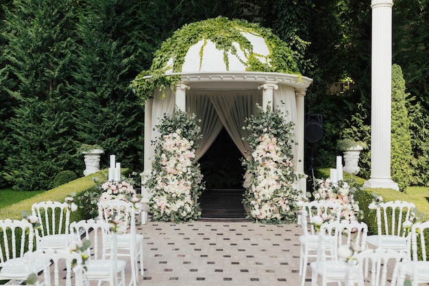 Arco de casamento decorado com flores de pano e hortaliças ao ar livre