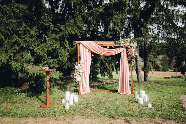 Arco de casamento lindo com velas no jardim.