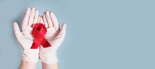 Foto arco de fita vermelha para aids e conscientização de hiv em banner médico de mãos com espaço de cópia