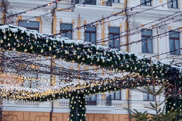 Arco de Natal estético ao ar livre e decorações com luzes brilhantes fundo ao ar livre Boas festas