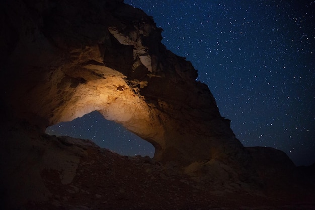 Arco de pedra sob o céu estrelado no deserto do Saara