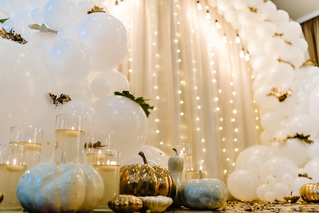 Arco decorado para cerimônia de casamento Balões brancos velas folhas de outono e pequenas abóboras Localização de outono e decoração de Halloween