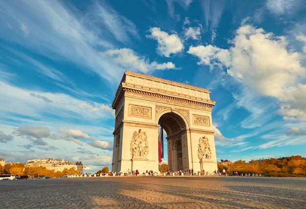Foto arco do triunfo em paris, com belas nuvens para trás no outono