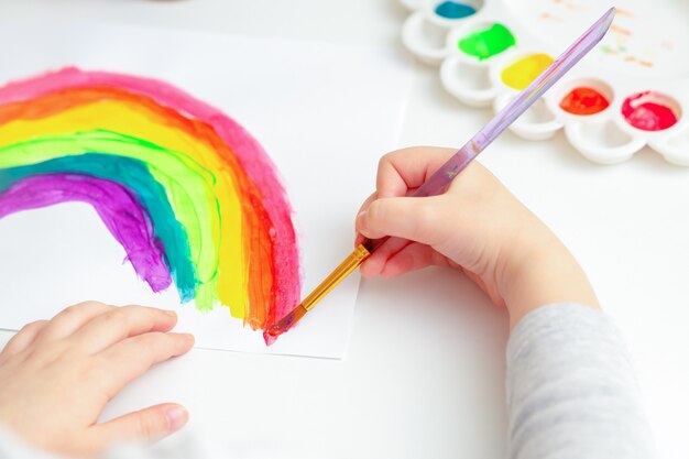 Arco iris de dibujo de manos del niño