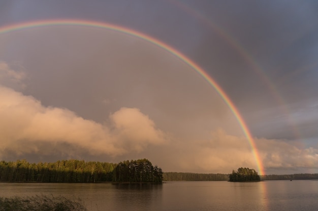 Arco-íris duplo sobre o lago na finlândia