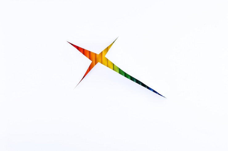 Foto un arco iris de lápices en una estrella cortada sobre un fondo de papel blanco, abstracción.