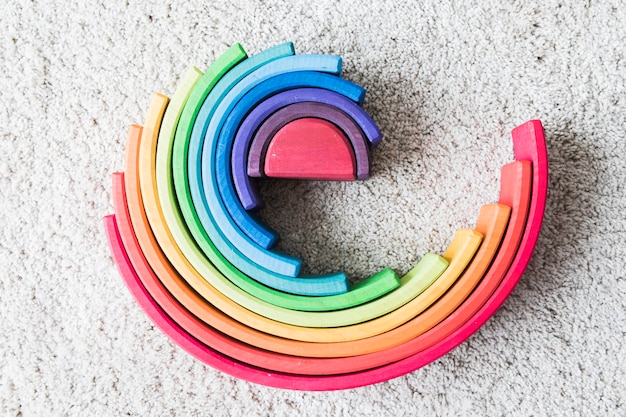 Arco iris de madera en la alfombra blanca