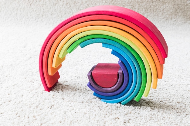 Arco iris de madera en la alfombra blanca