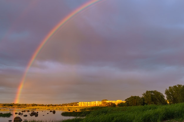 Arco iris sobre la costa pedregosa al atardecer