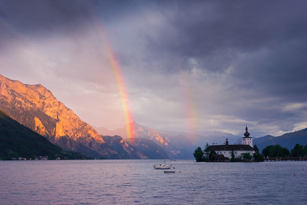 Arco-íris sobre o lago e as montanhas, Áustria, Gmunden, Alpes.